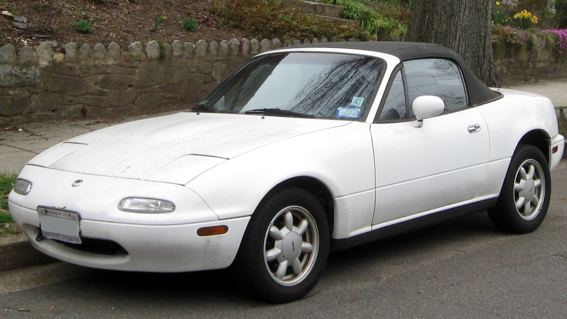 a white sports car parked on the side of the road.
