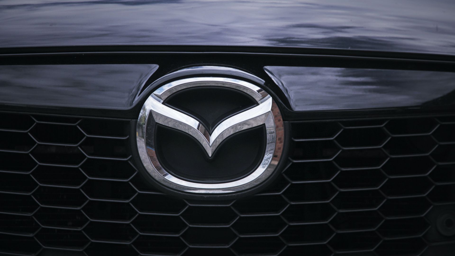 a close up of a mazda logo on a car.