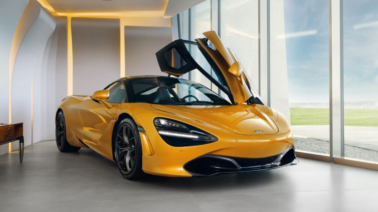 a yellow sports car parked in front of a window.