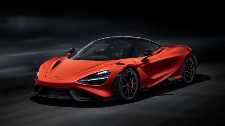 an orange sports car in a dark room.