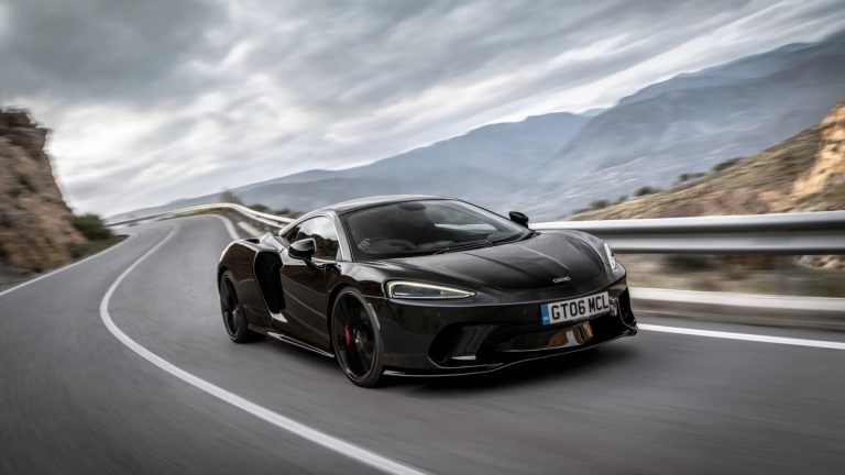 a black sports car driving down the road.