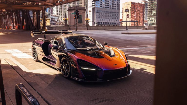 a sports car driving down a city street.