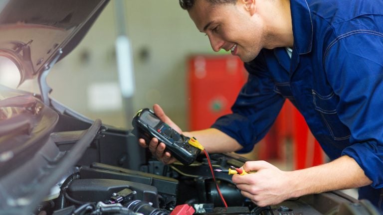 a man working on a car in a garage.