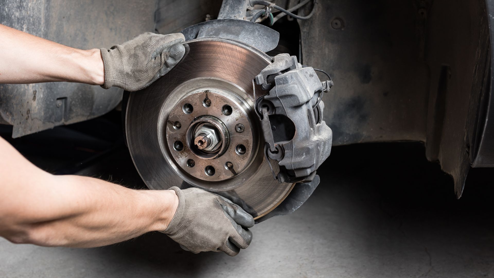 a close up of a person changing a brake on a car.