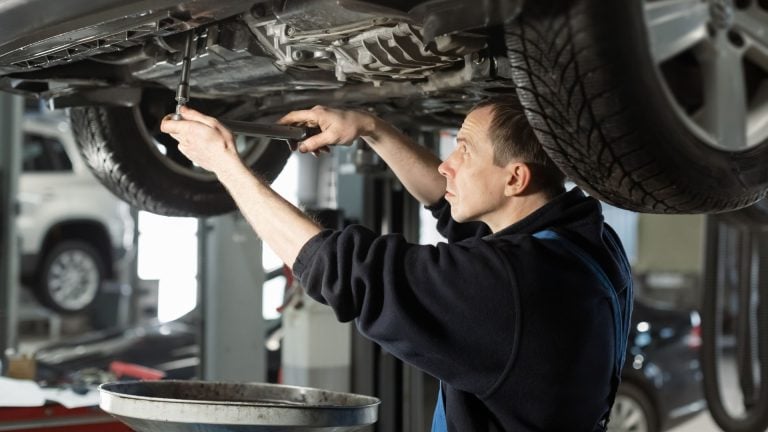 a man working on a car in a garage.