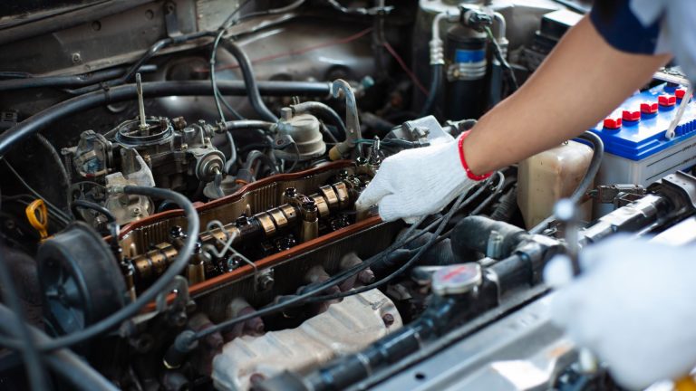 a person working on an engine in a car.