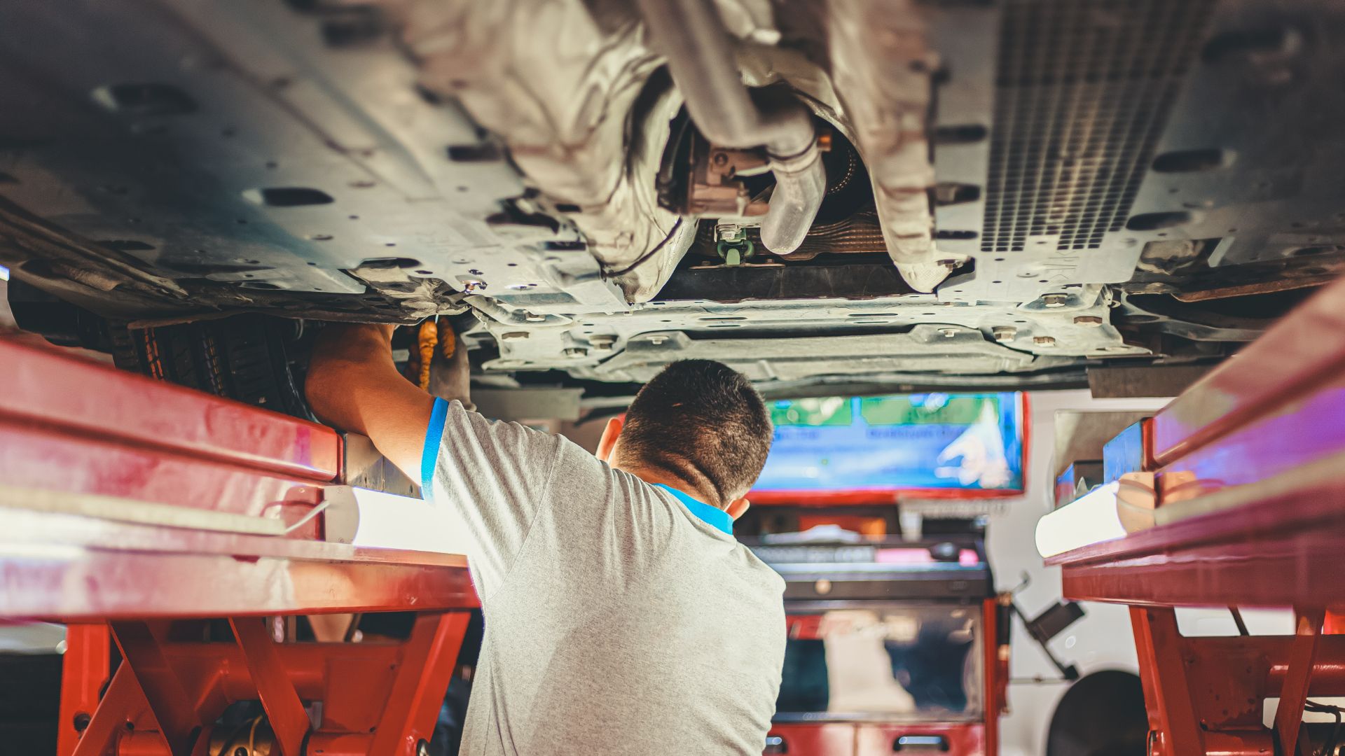 a man working on the underside of a vehicle.
