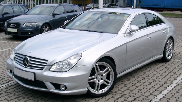 a silver car parked in a parking lot next to other cars.