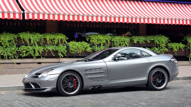 a silver sports car parked in front of a building.
