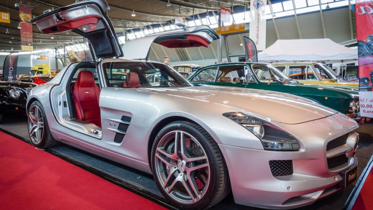 a silver sports car with its doors open.