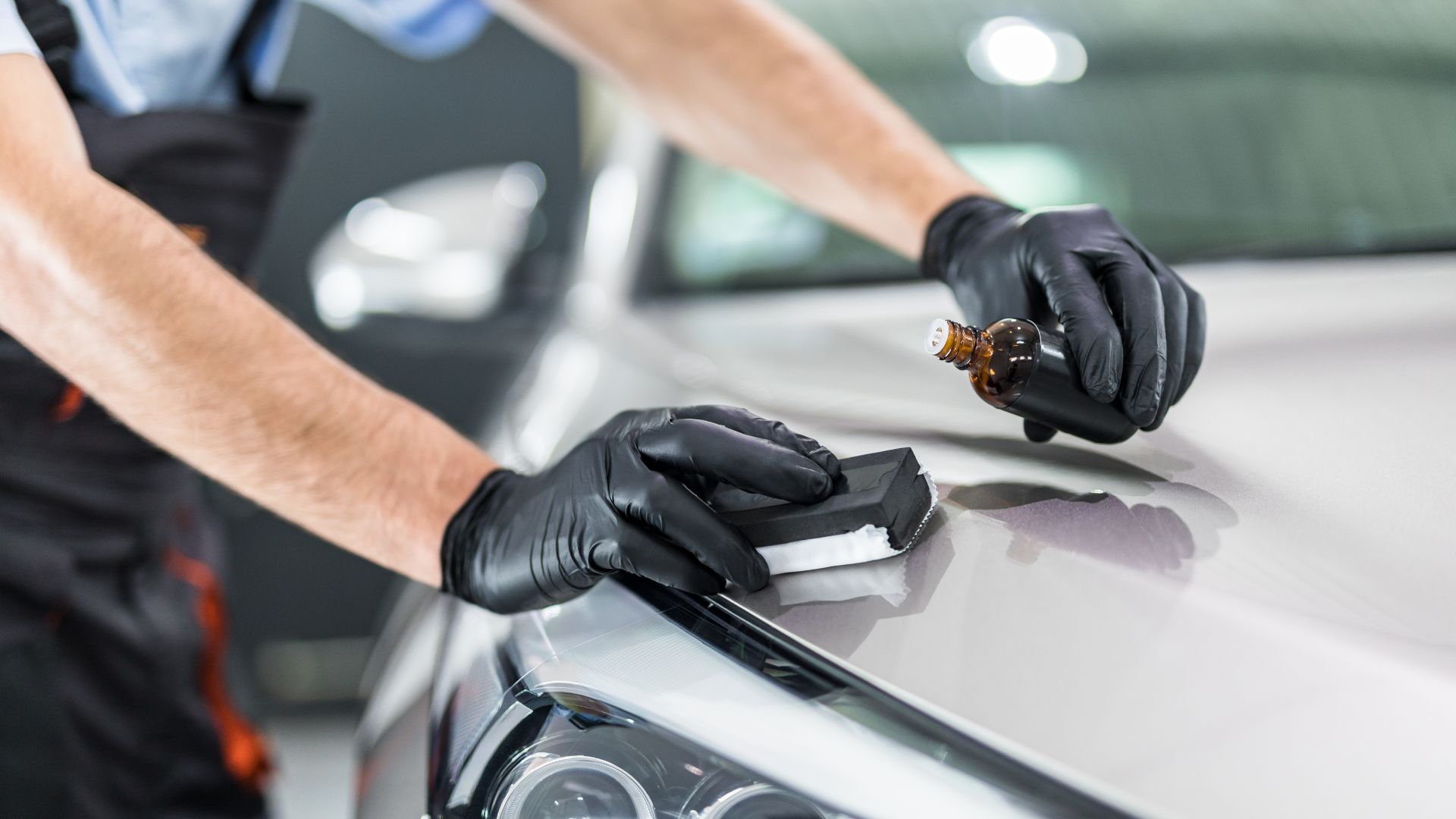 a man polishing the hood of a car.