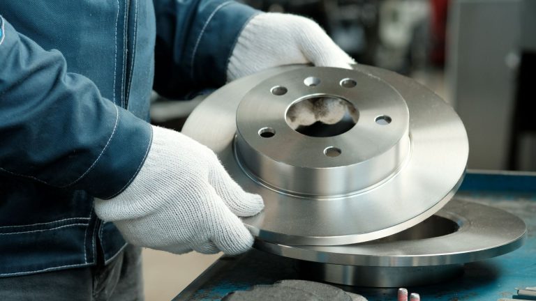 a close up of a person working on a metal object.