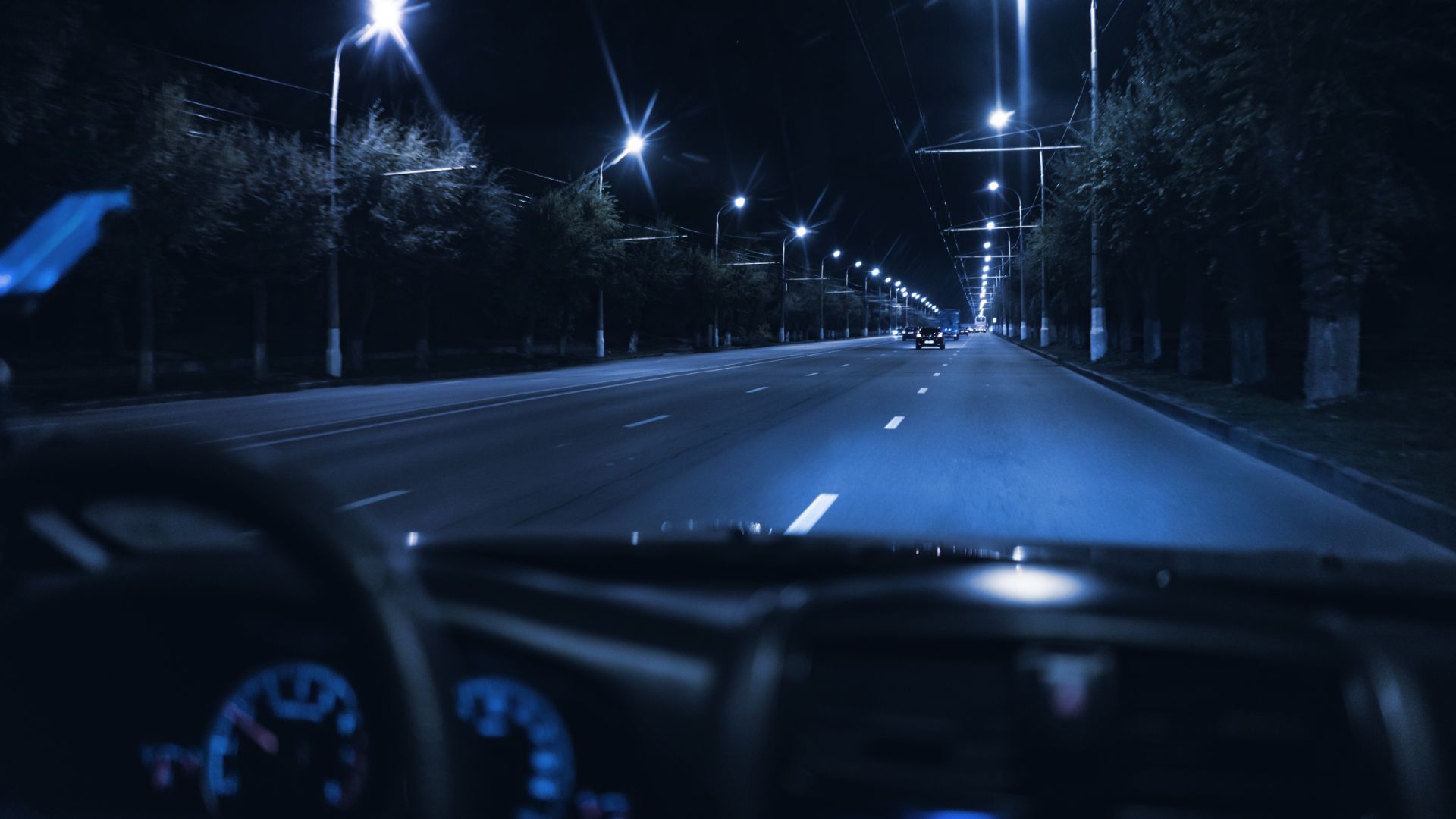 a car driving down a street at night.