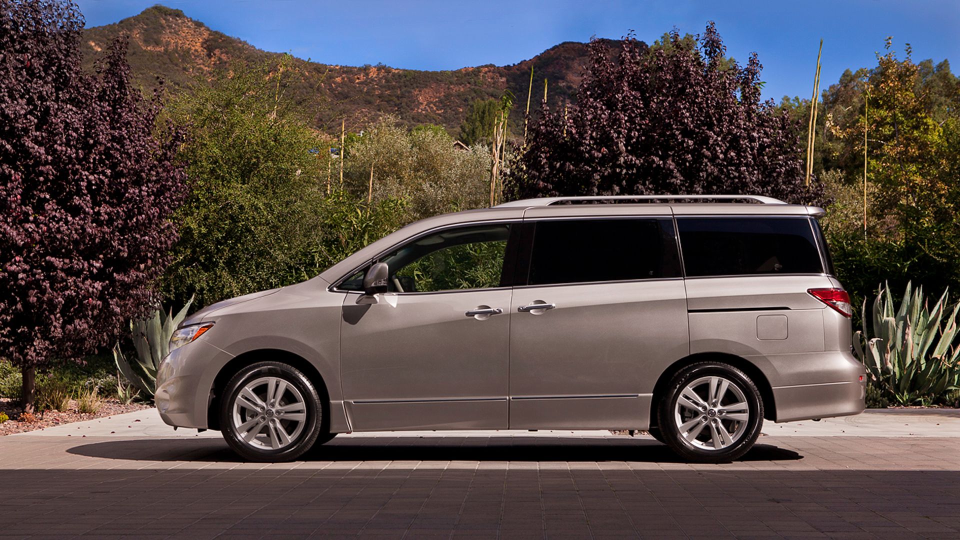 a silver van parked in front of a mountain.