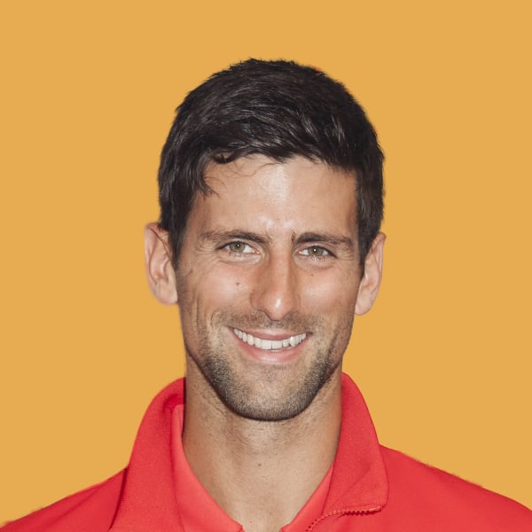a man in a red shirt smiling at the camera.
