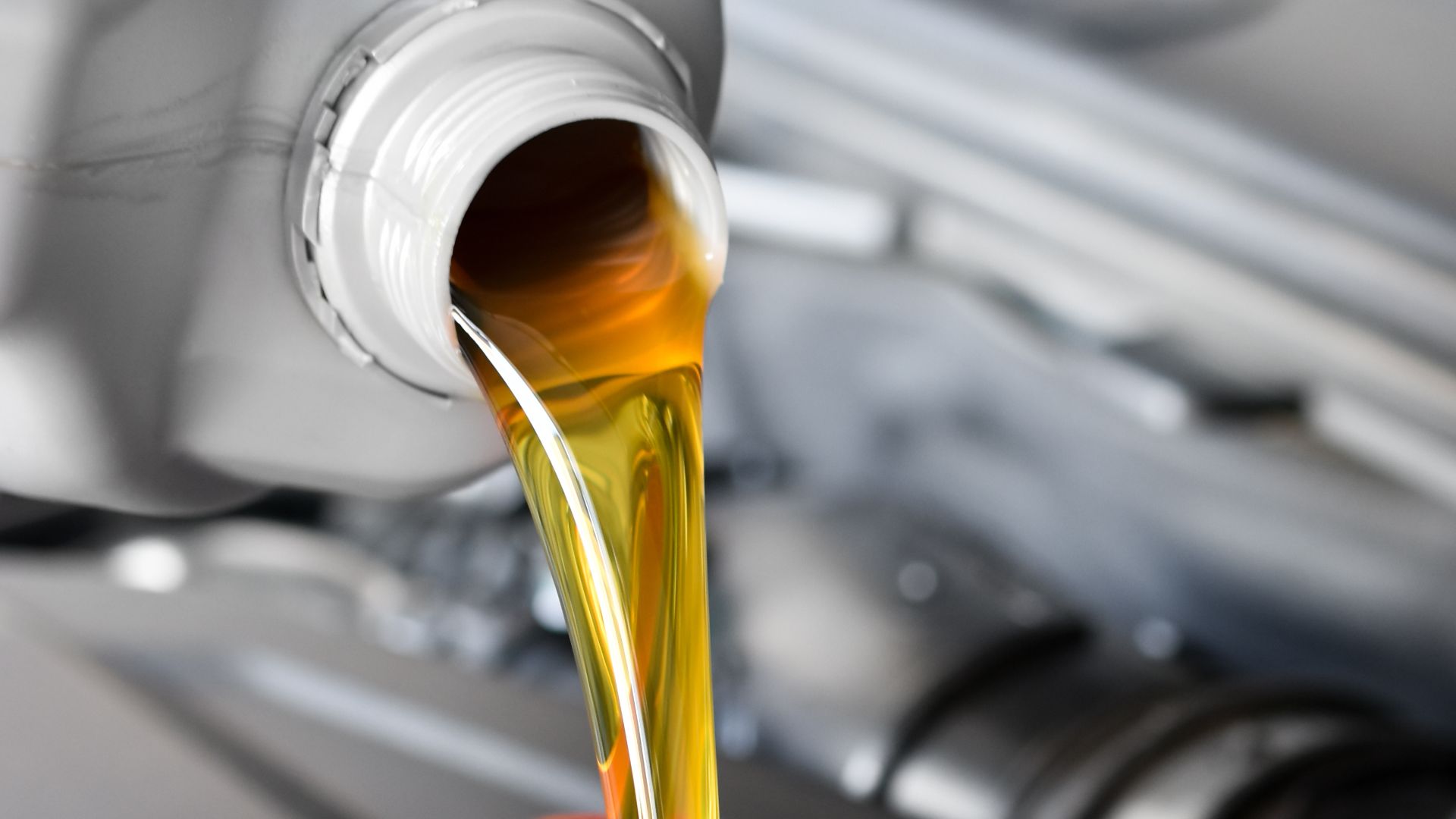 a close up of oil being poured into a car's engine.