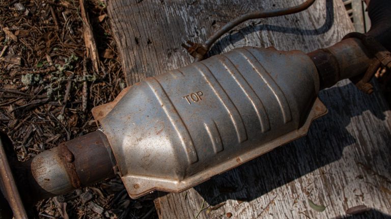 an old metal object sitting on top of a wooden table.