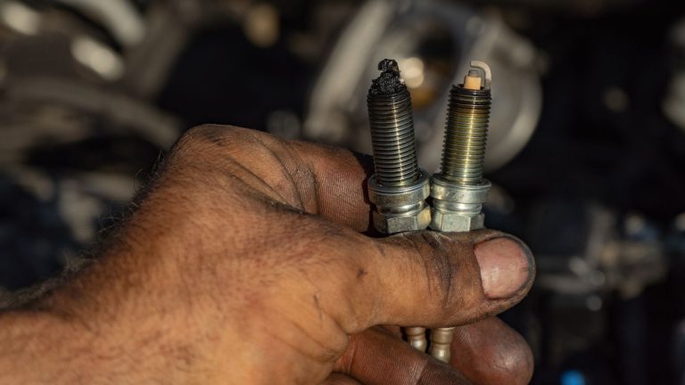 a man holding two screws in his hand.