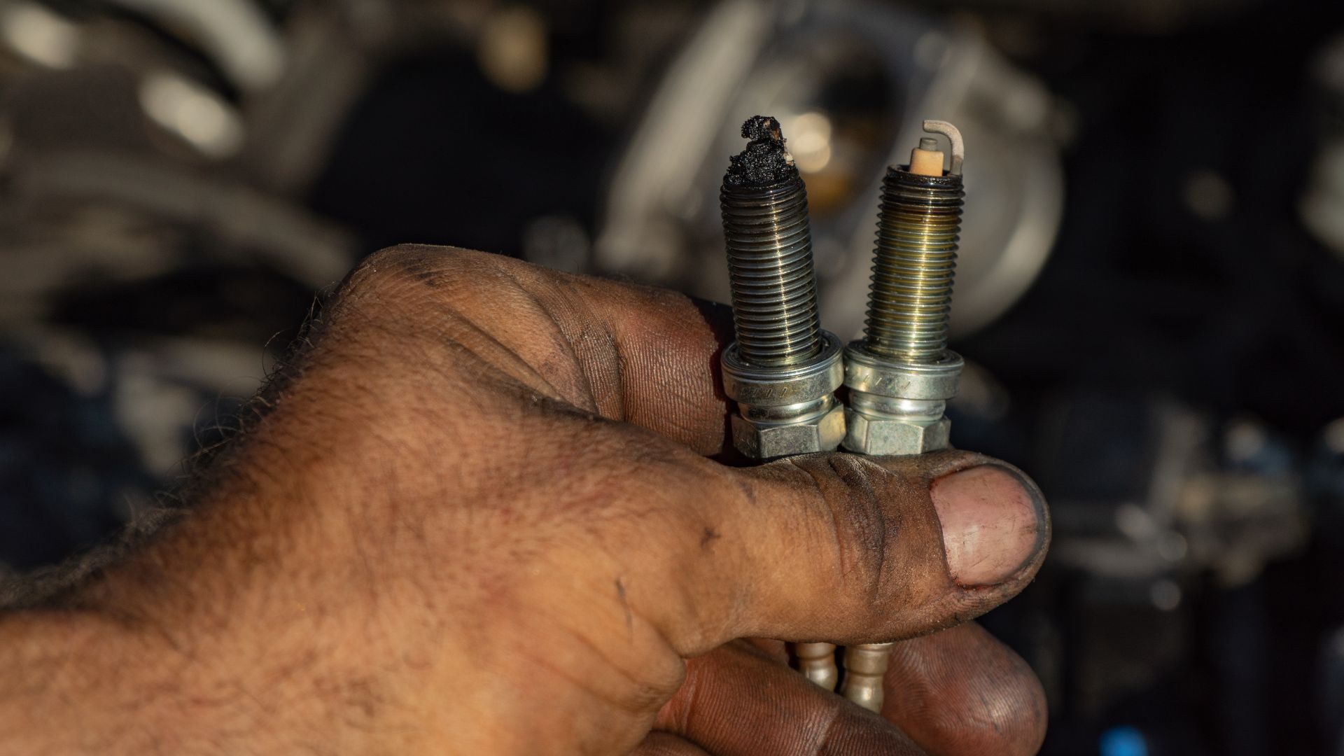 a man holding two screws in his hand.