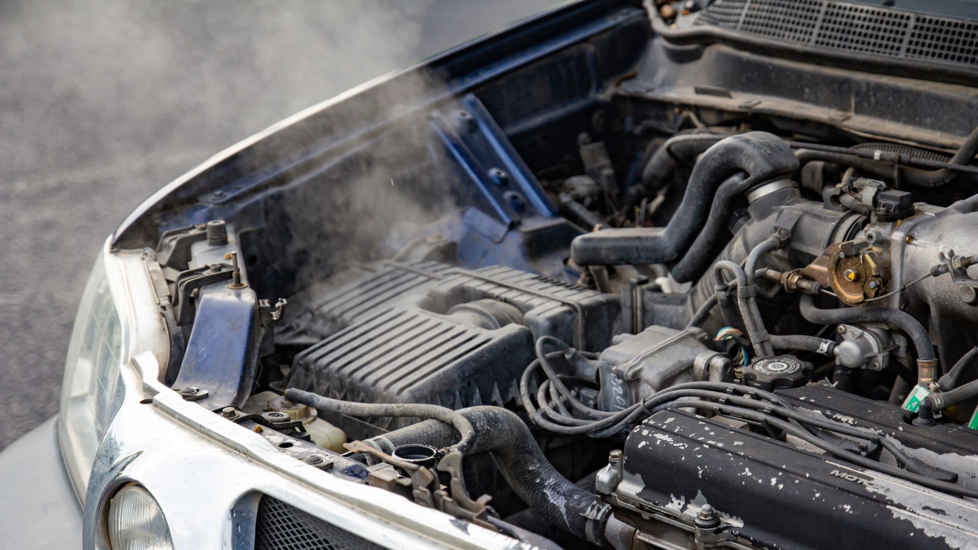 the engine compartment of a car with dust coming out of it.