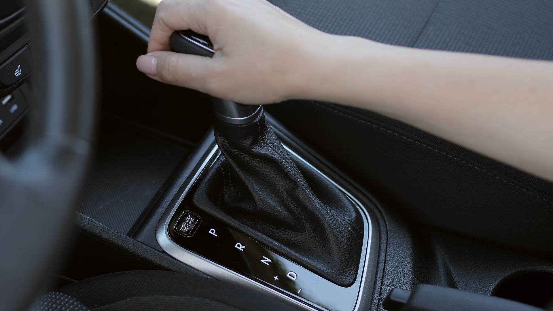 a person is holding the steering wheel of a car.