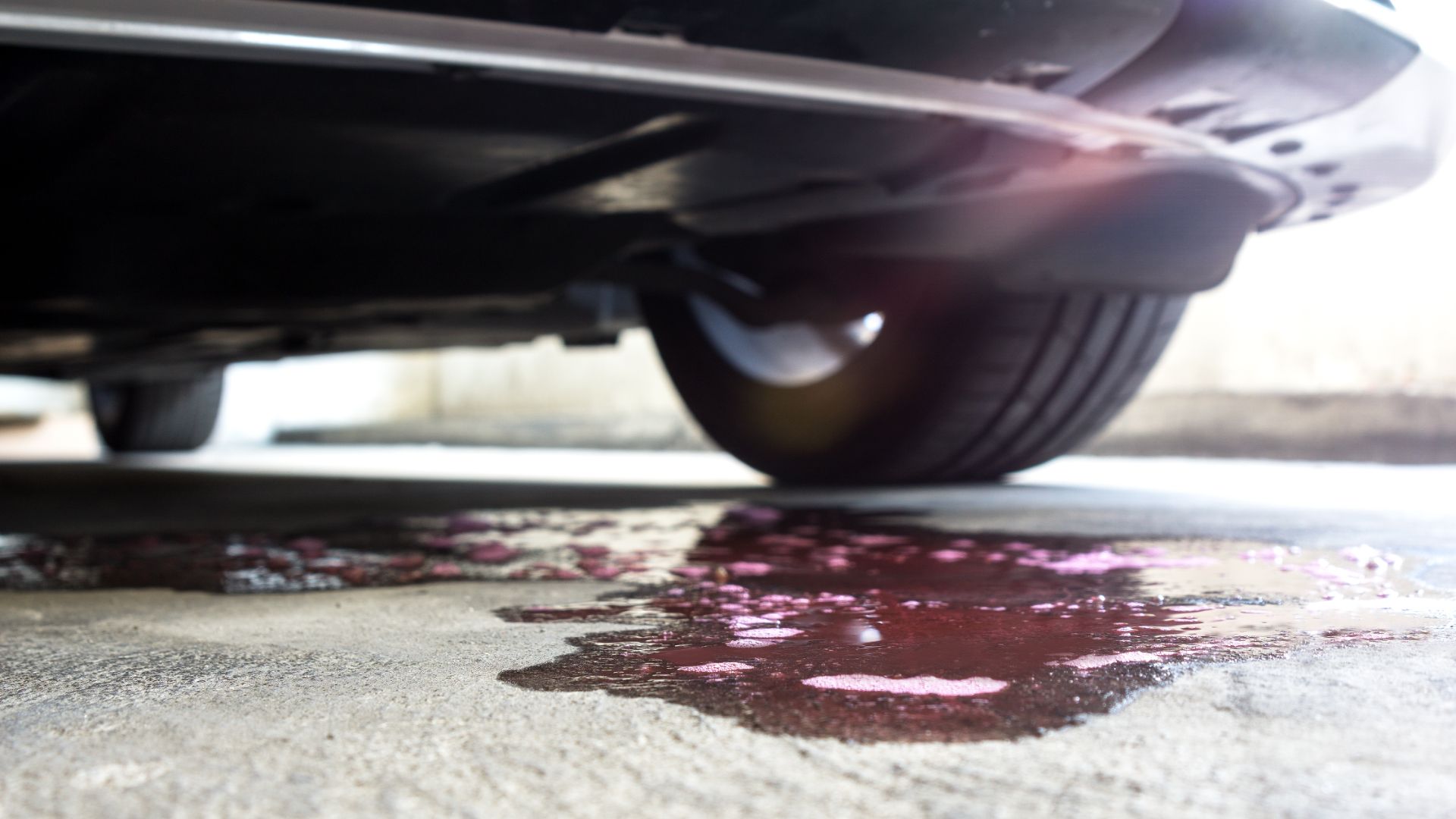 a close up of a car's tire with a puddle of paint on the.