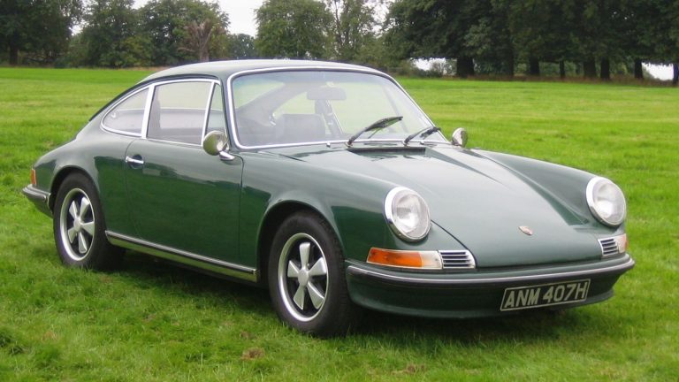 a green sports car parked in a grassy field.