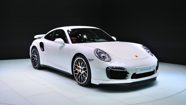 a white porsche sports car on display at a show.