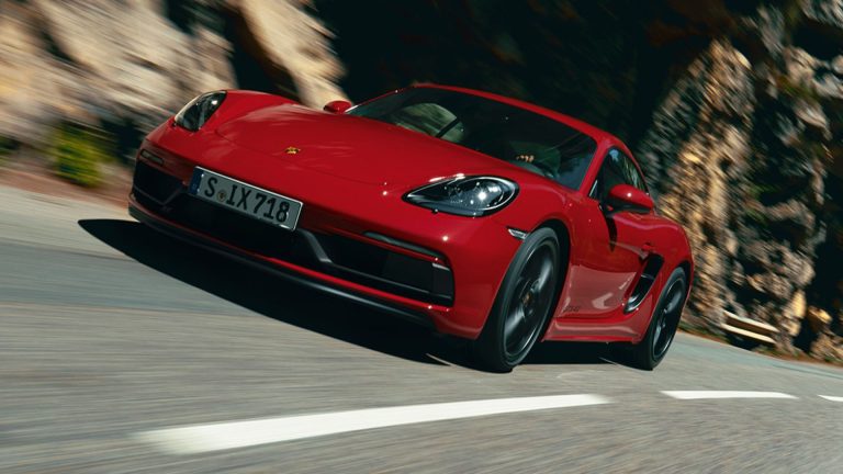 a red sports car driving down a road.