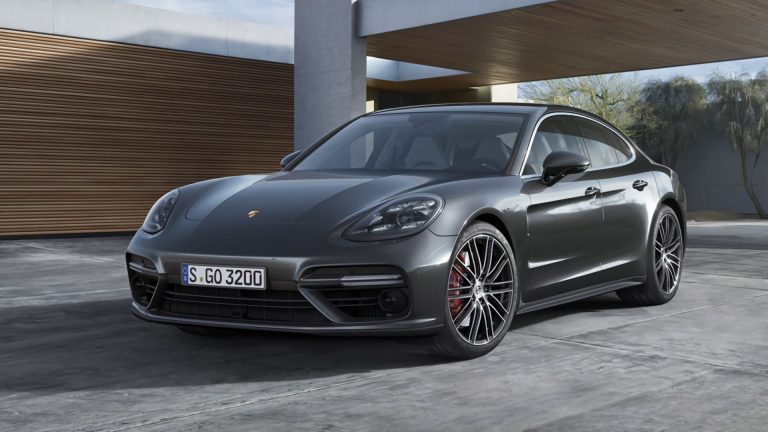 a grey porsche panamer parked in front of a building.