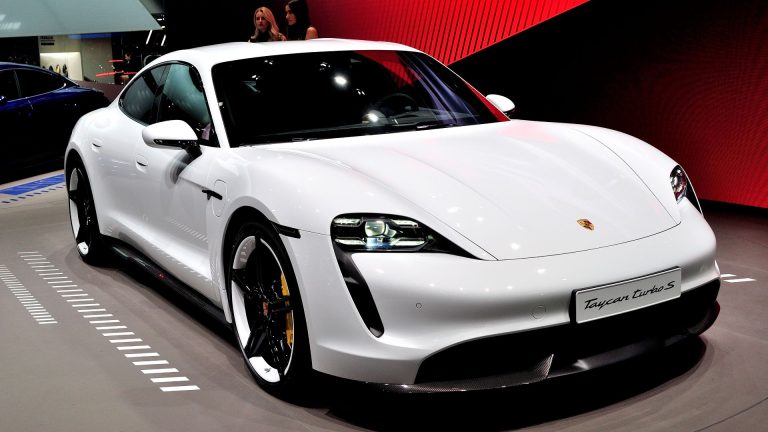 a white sports car on display at a car show.