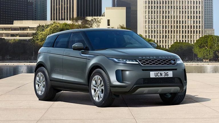 a grey range rover parked in front of a city skyline.