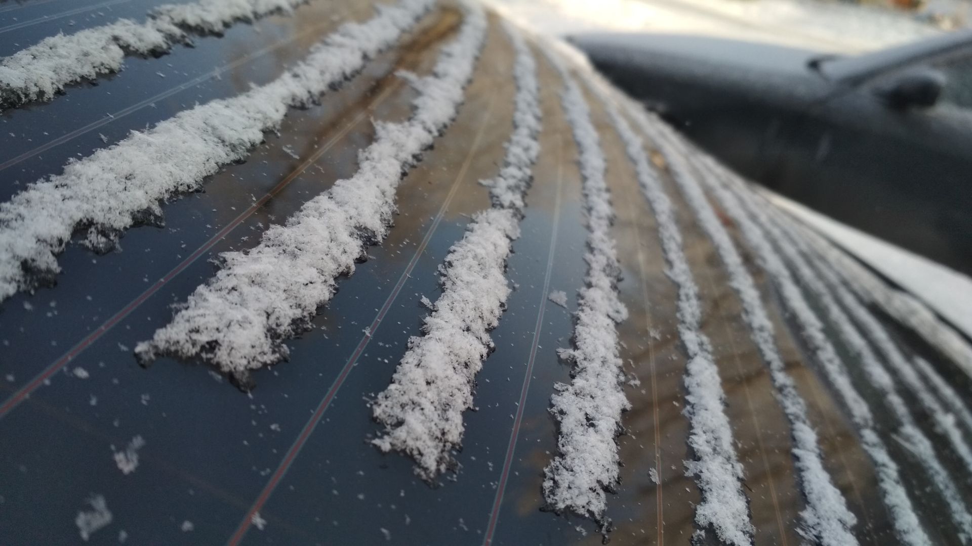 snow is on the roof of a car.