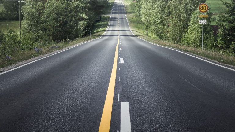 an empty road with a yellow line in the middle of it.