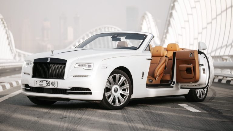 a white rolls royce parked on the side of a road.