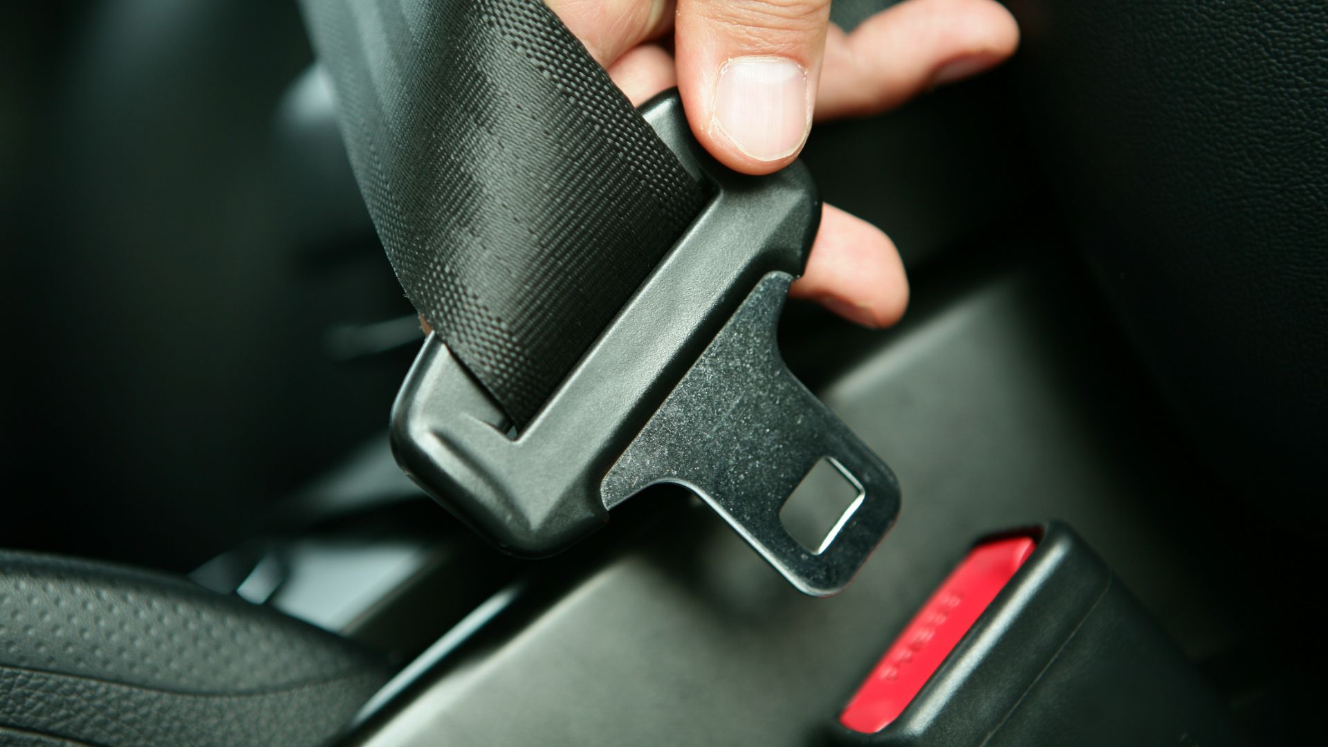 a person is holding the door handle of a car.