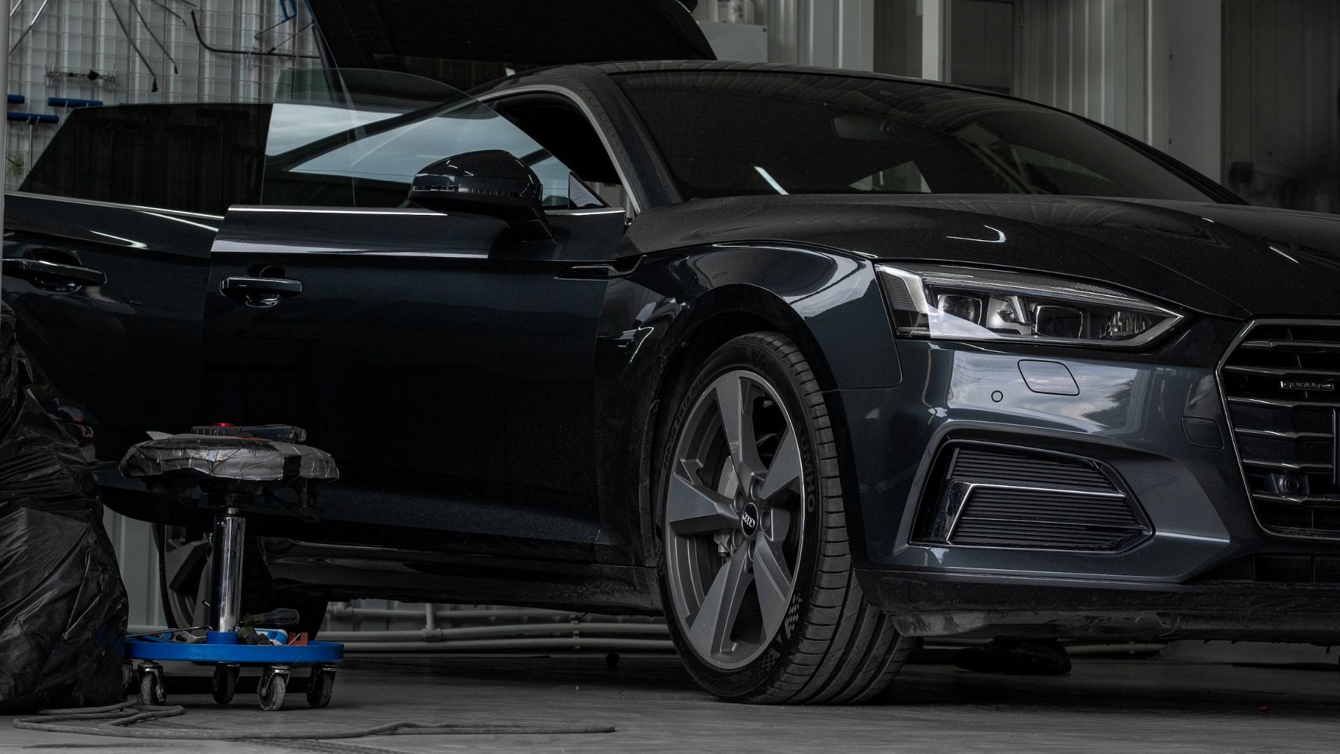 a man working on a car in a garage.