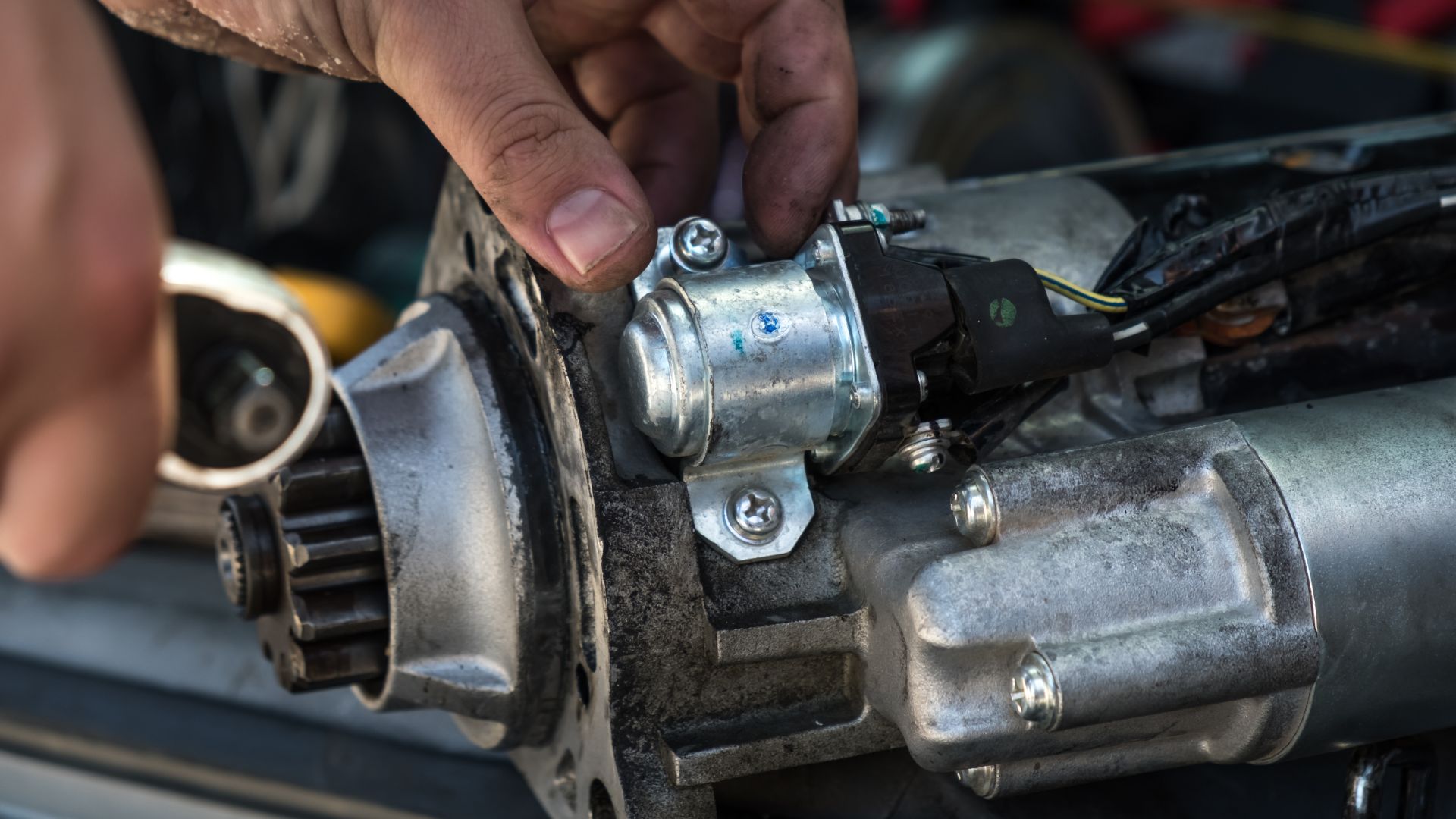 a close up of a person working on a motor.