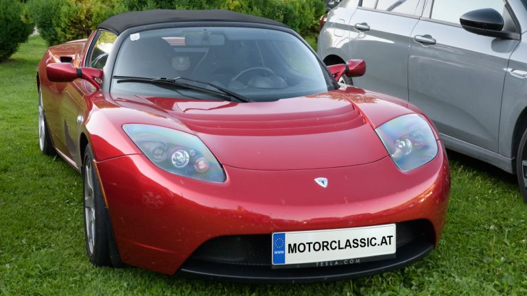 a red sports car parked next to a silver sports car.