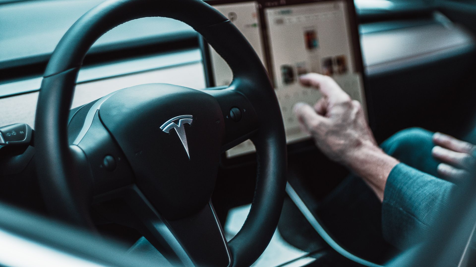 a man holding a tablet while driving a car.