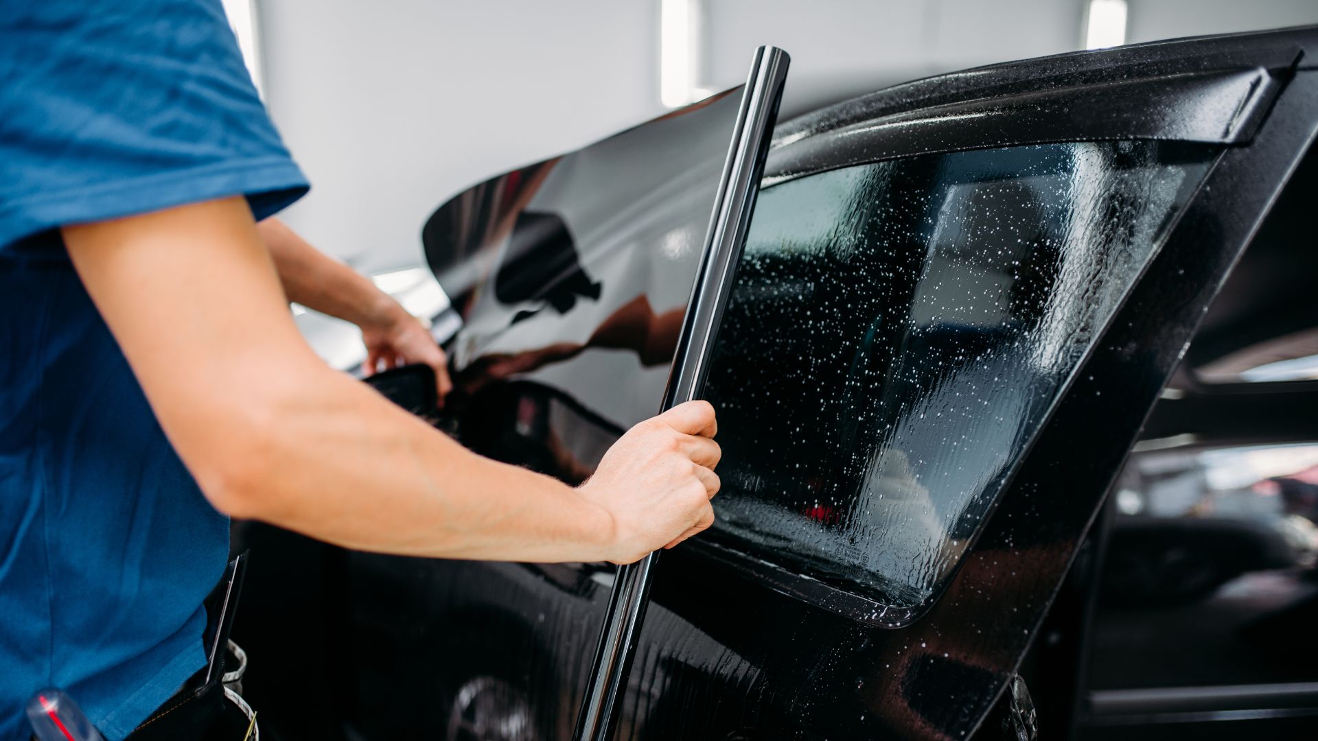 a man waxing a car in a garage.