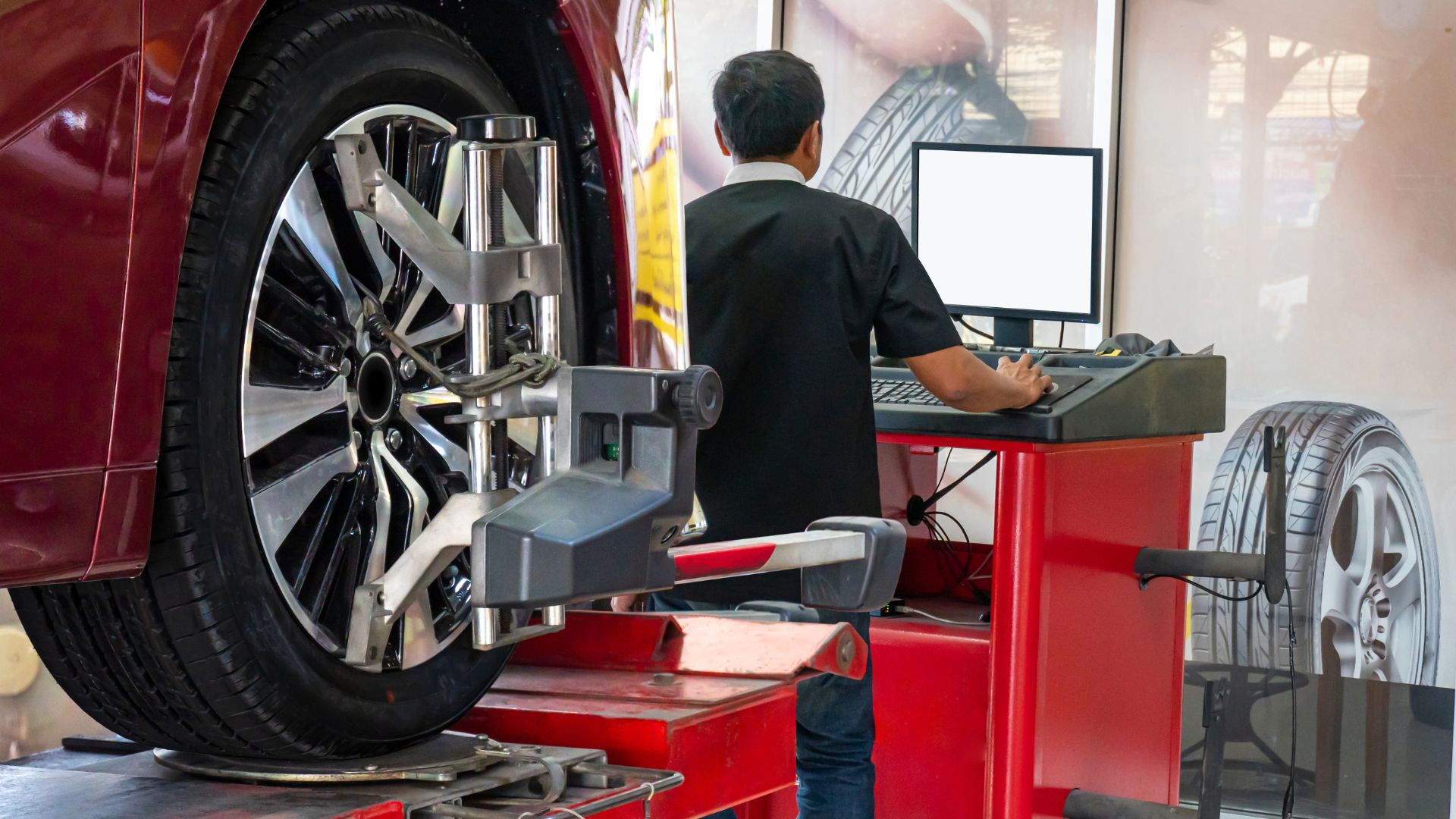 a man working on a tire on a car.