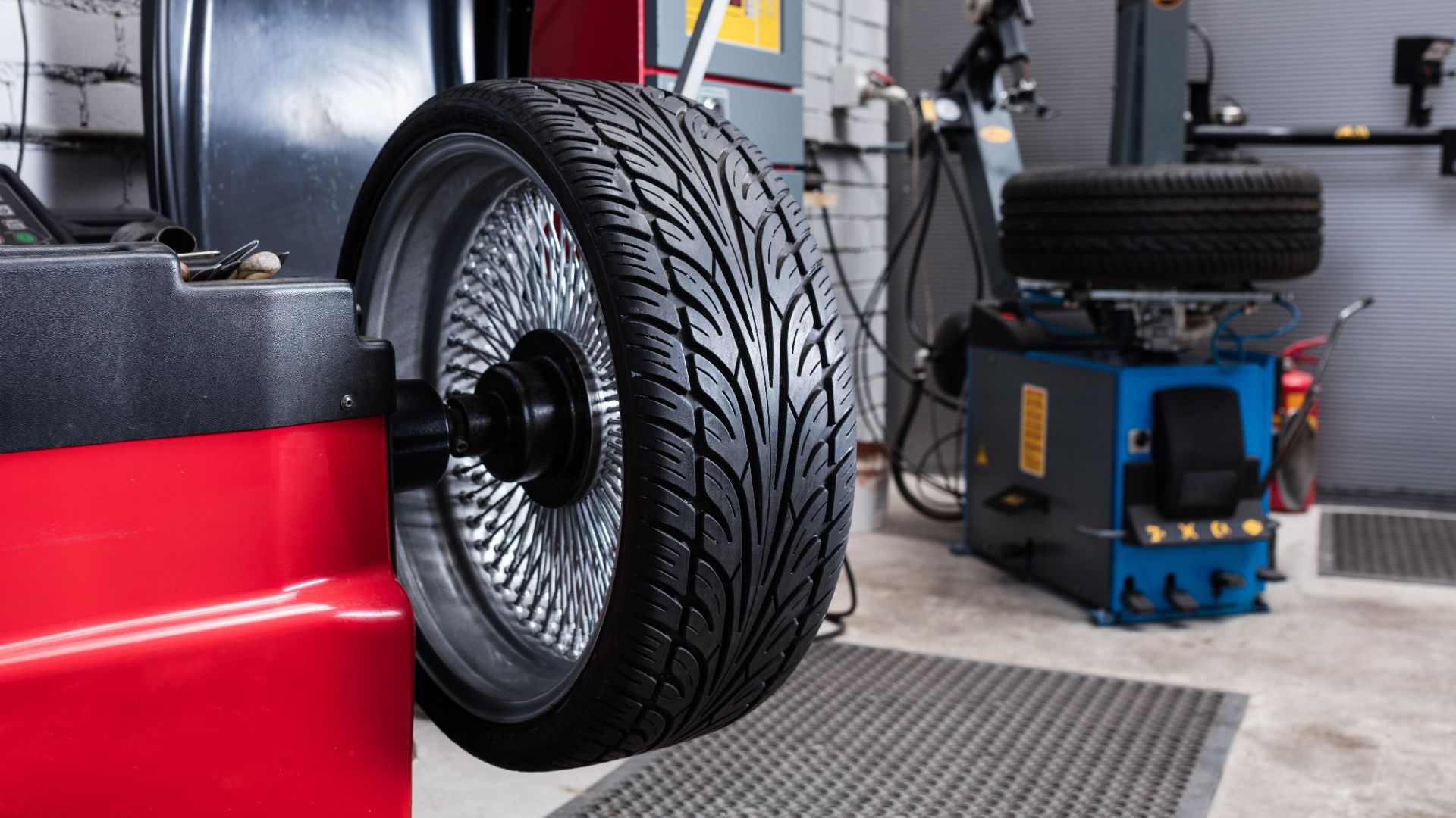 a tire on a red car in a garage.