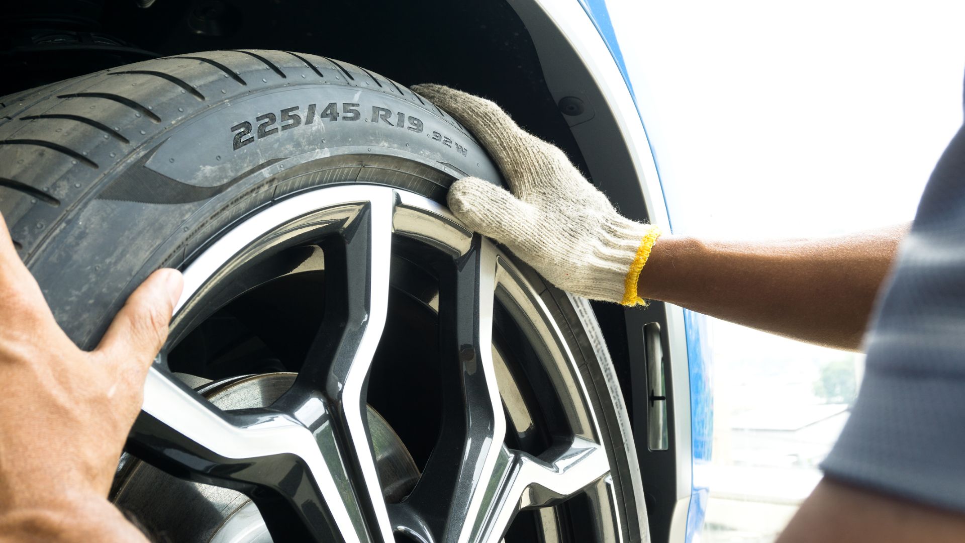 a man is cleaning a tire with a cloth.