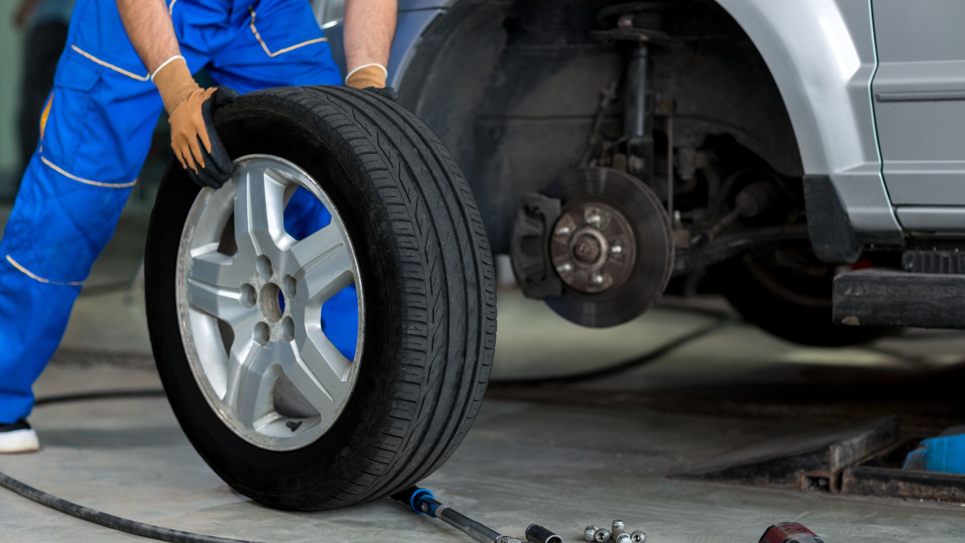 a man working on a tire in a garage.