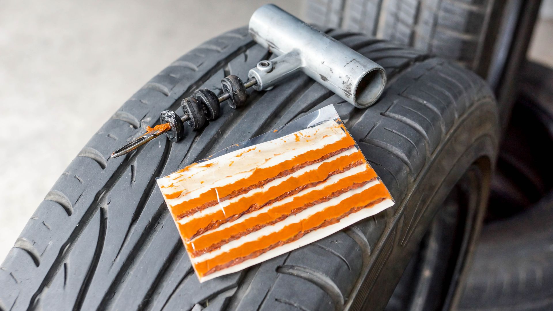 an orange and white piece of paper sitting on top of a tire.