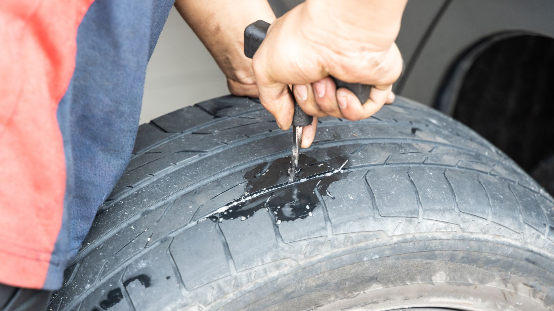 a person is holding a wrench on a tire.