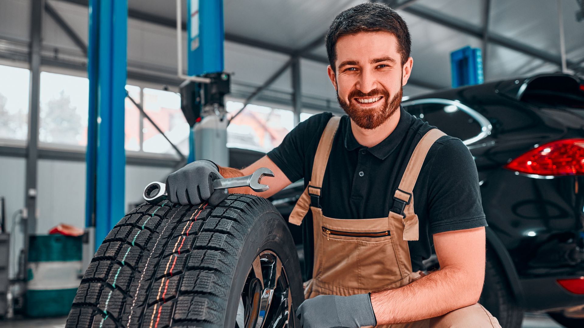 a man is working on a tire in a garage.