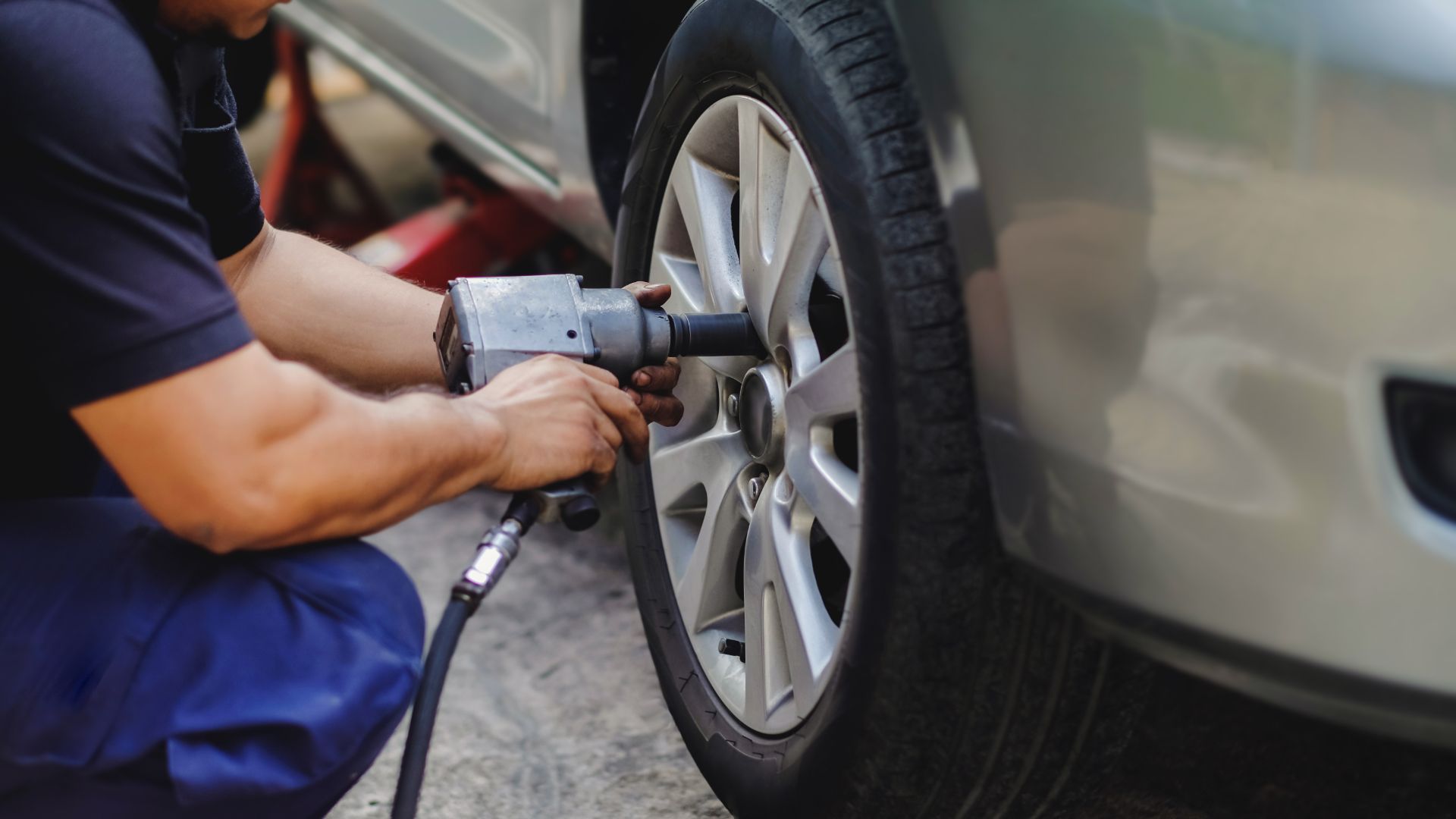 a man working on a tire with a wrench.