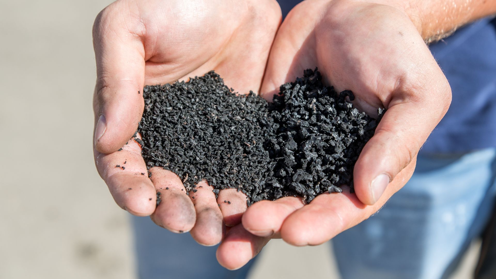 a person holding a handful of dirt in their hands.